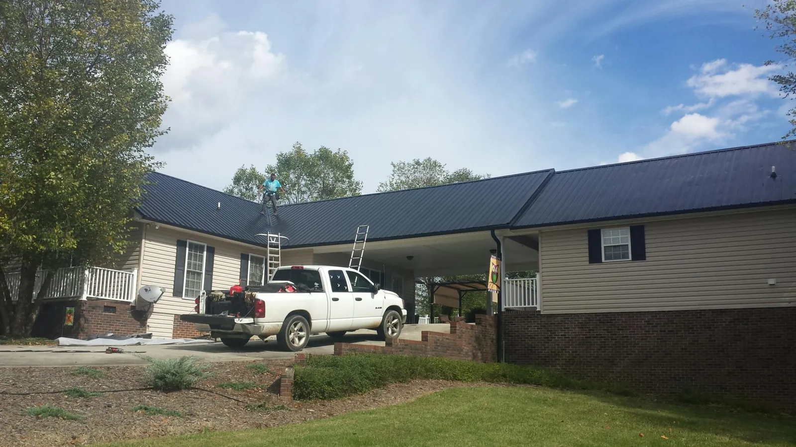 Black metal roof over a home and attached breezeway with ladders set in Gatlinburg