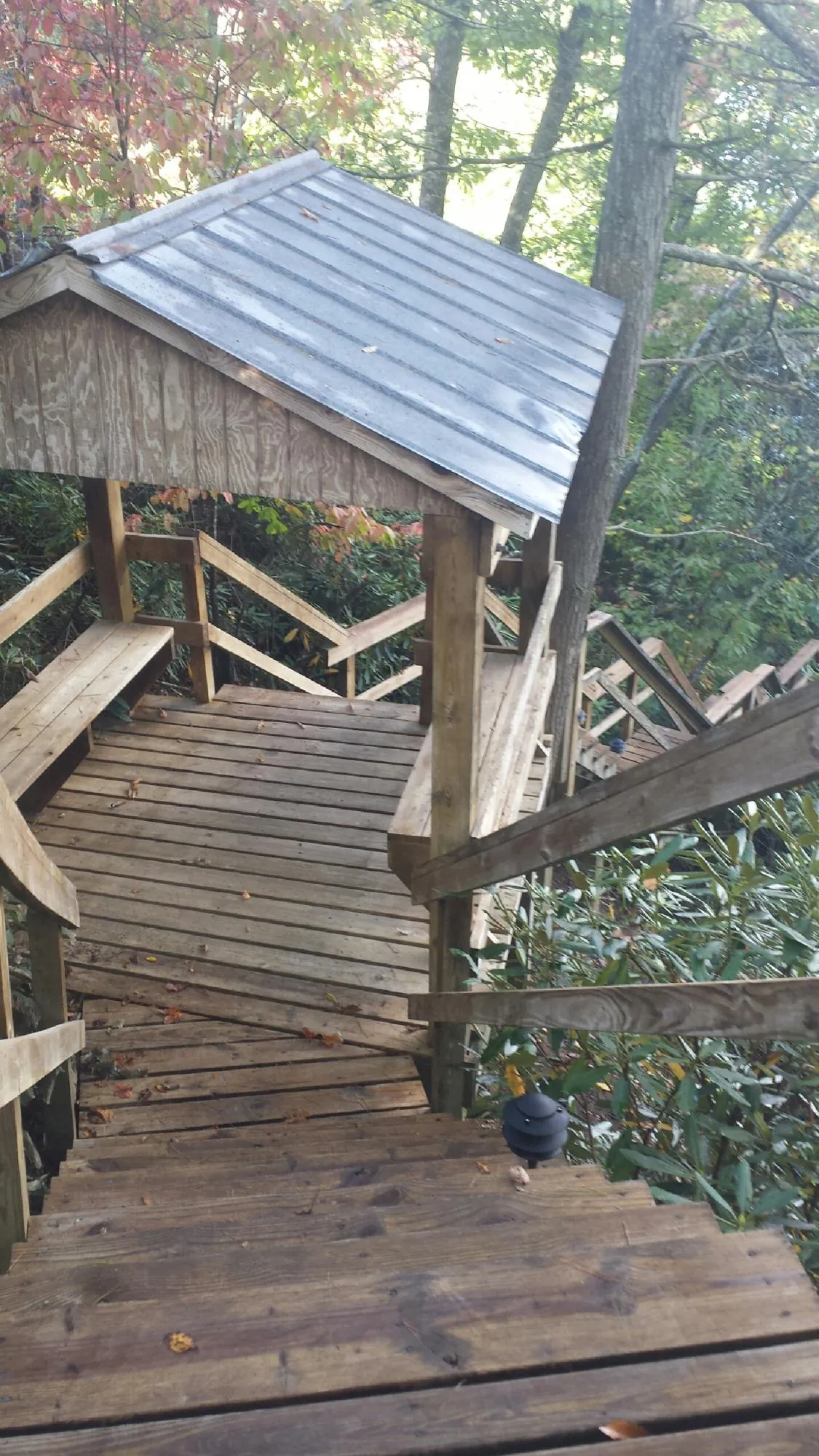 Metal roofed shelter over wooden steps on a wooded walkway — Skylight Repair & Installation work by our crew in Gatlinburg