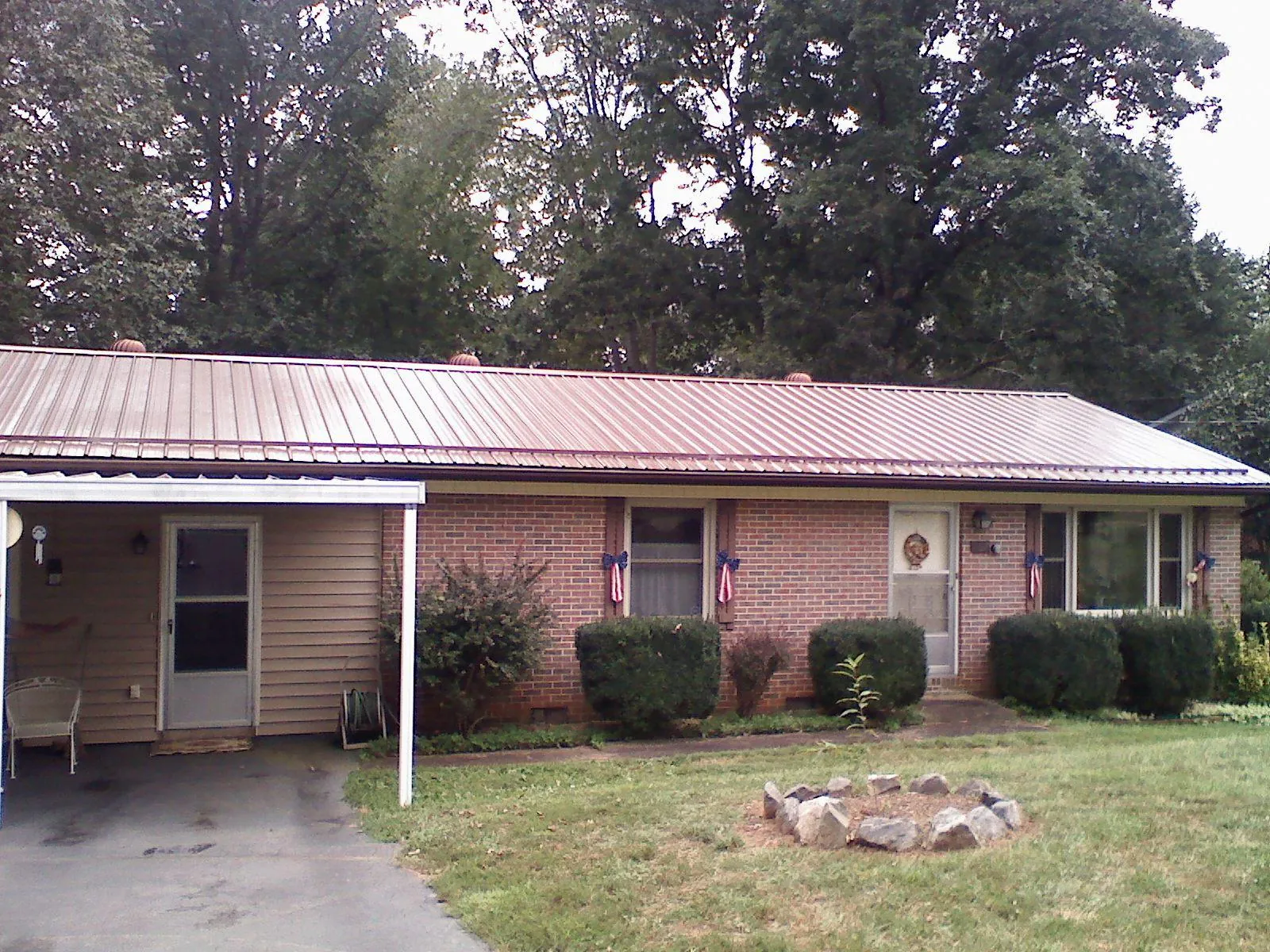 Bronze metal roof and carport on a brick ranch home — Roof Repair work by our crew in Gatlinburg